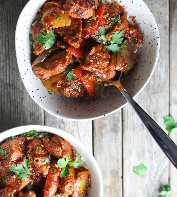Bowl of red Harissa Chicken with Roasted Veggies
