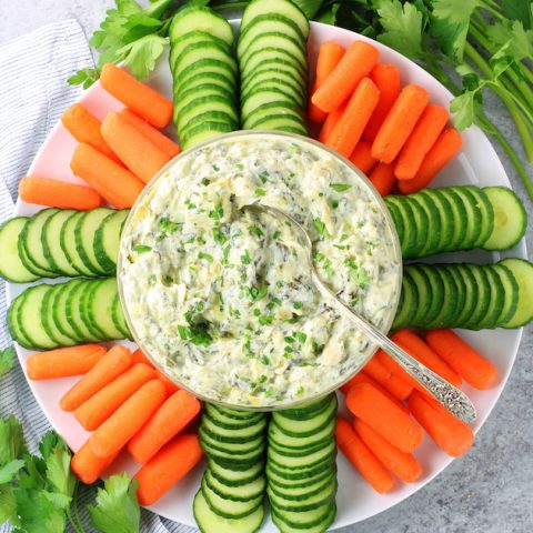 bowl of spinach artichoke dip with veggies