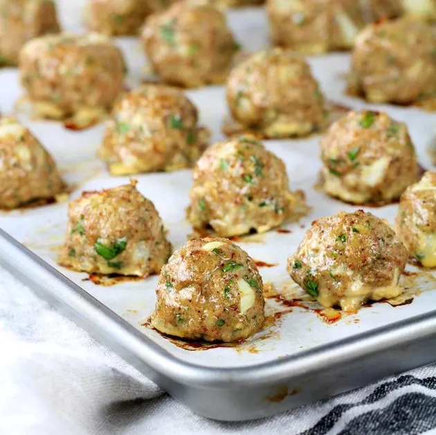 Baking sheet with cooked meatballs on parchment