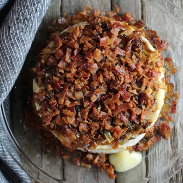 Baked brie topped with bacon and caramelized onions in a pie dish
