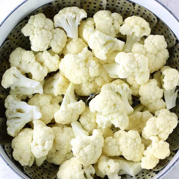 cauliflower florets in a steamer basket
